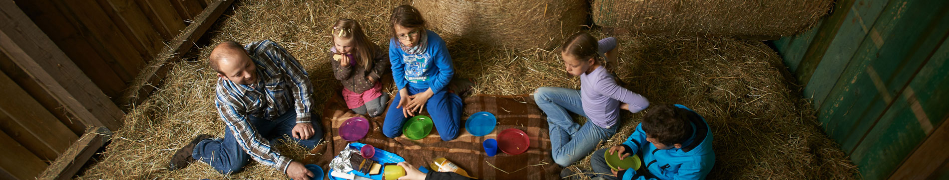 Kinder beim Picknicken in der Spielscheune